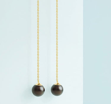 Long earrings in gold with black pearl stone